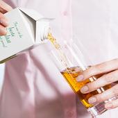 Woman pours apple juice into glass