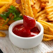 Homemade potato ridge chips, fries with ketchup on white wooden board