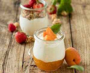 Joghurt with fruits on wooden background