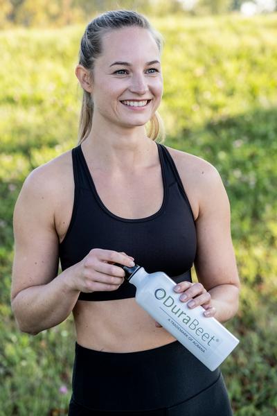 Sportliche junge Frau mit Trinkflasche